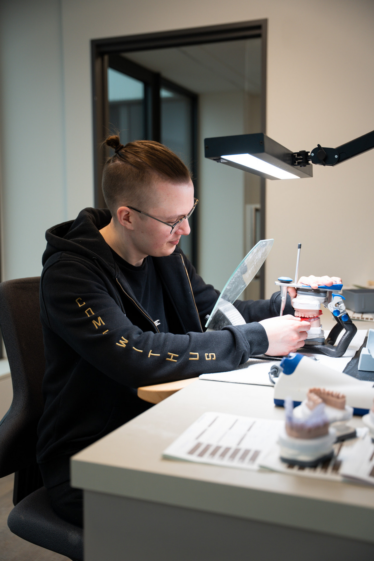 Zahntechniker bei der Arbeit am Artikulator im Denta1 Labor